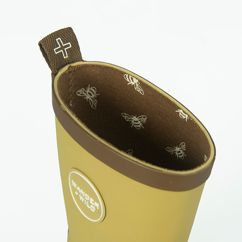 Close up of children's yellow gumboot featuring bee print on soft cotton lining